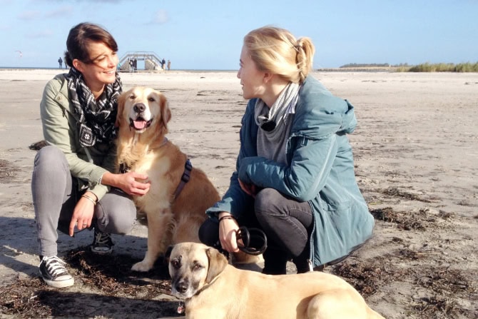 Hundegesundheitstrainer Ausbildung ATM - 2 Frauen mit 2 Hunden am Strand