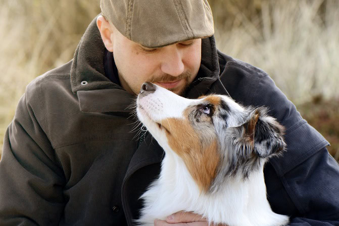 Tierpsychosomatik Ausbildung ATM - Border Collie schaut zu Mann mit Schirmmütze auf